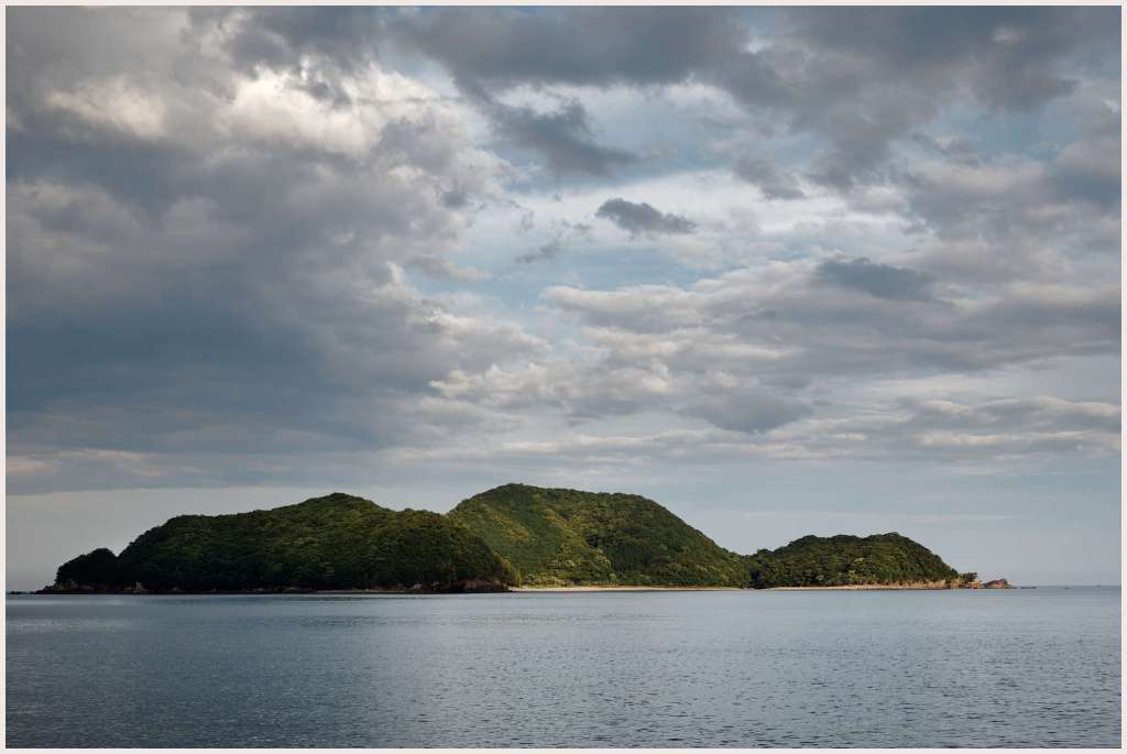 The last rays of sunlight hit an Suzushima Island in Toyoura Bay. Kihoku, Mie, Japan.