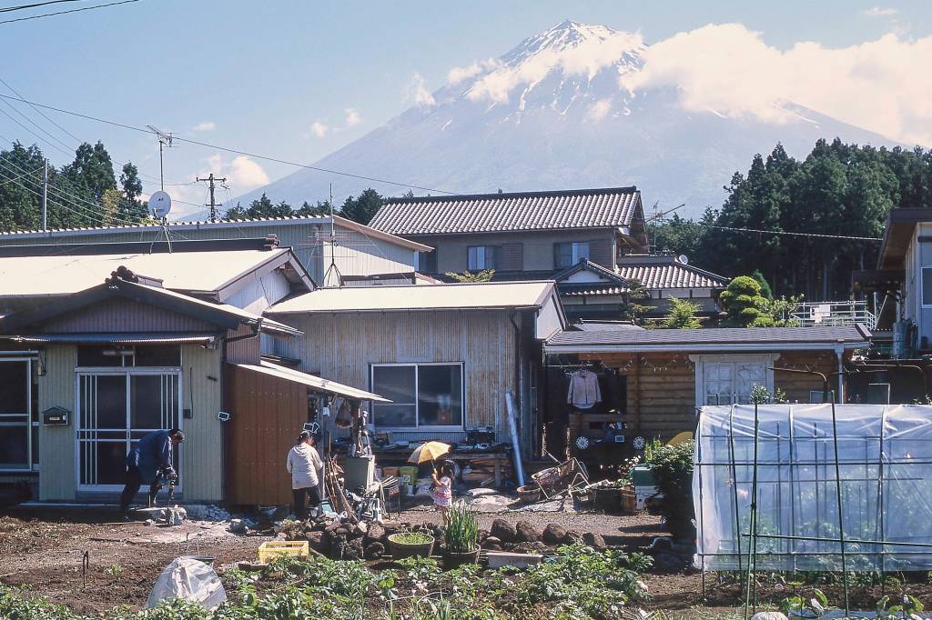 Mt. Fuji with a family and house in the foreground.